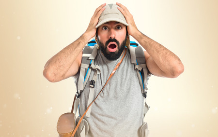 Backpacker doing surprise gesture over white backgroundの写真素材