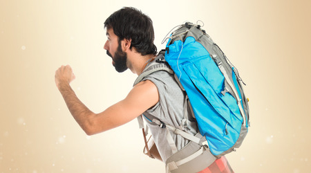 Young backpacker running over white backgroundの写真素材