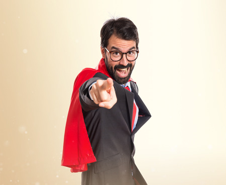 Businessman dressed like superhero pointing to the frontの写真素材