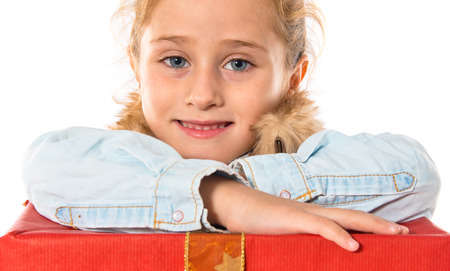 Blonde little girl holding a big red giftの写真素材