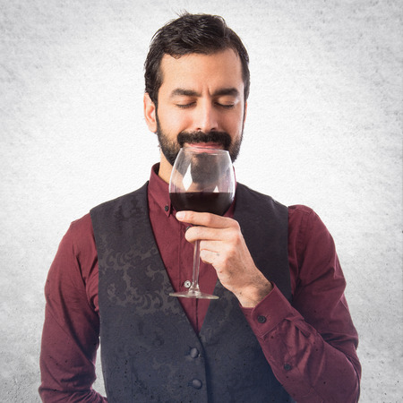 Man wearing waistcoat holding a wine glass