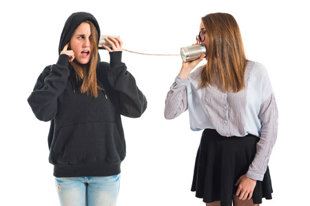 Twin sisters talking through tin phone