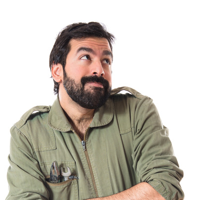 Mechanic having doubts over white backgroundの写真素材