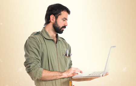 mechanic with laptop over white backgroundの写真素材