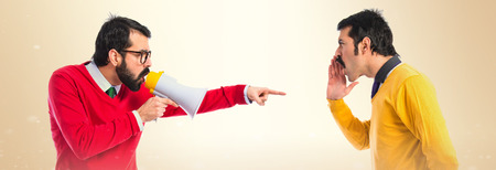 Twin brothers shouting over white backgroundの写真素材