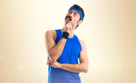 Crazy runner thinking over white backgroundの写真素材