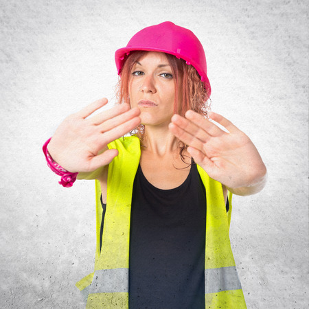 Worker woman making stop sign over white backgroundの写真素材