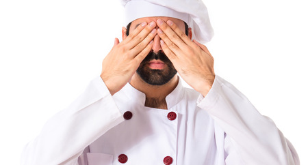 Chef covering his eyes over white backgroundの写真素材