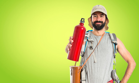 Backpacker drinking water over white background