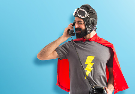 Superhero talking to vintage phoneの写真素材