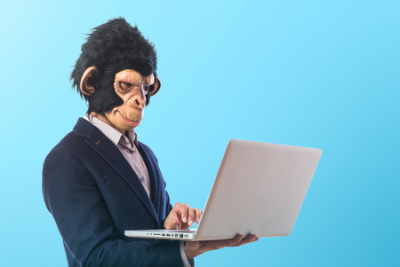 Monkey man with laptop over white backgroundの写真素材