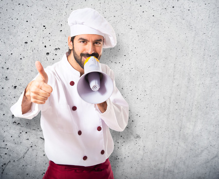 Happy chef shouting by megaphoneの写真素材