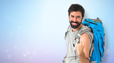 Lucky backpacker over isolated white backgroundの写真素材