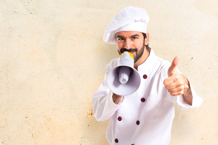 Happy chef shouting by megaphoneの写真素材