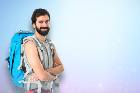 Backpacker with his arms crossed over white backgroundの写真素材