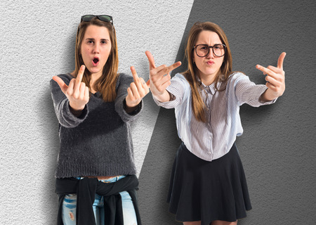 Twin sisters making horn gestureの写真素材