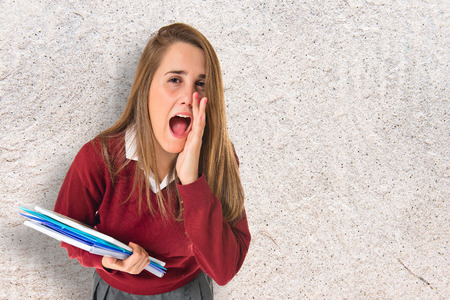 Student shouting over isolated white backgroundの写真素材