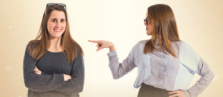 Pretty girl presenting her twin sisterの写真素材