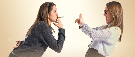 One girl smoking and other doing No gestureの写真素材