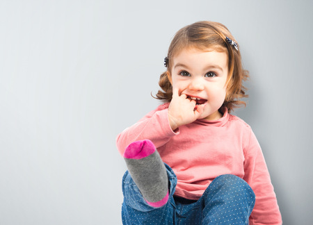 Cute girl sitting and laughing over white background