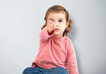 Cute baby pointing to the front over white backgroundの写真素材