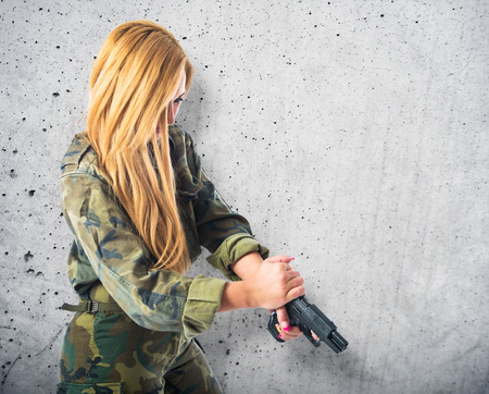 Military woman carrying a gunの写真素材