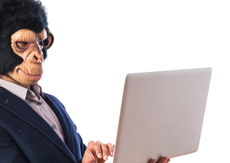 Monkey man with laptop over white backgroundの写真素材