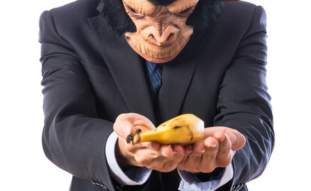 ape man offering a bananaの写真素材