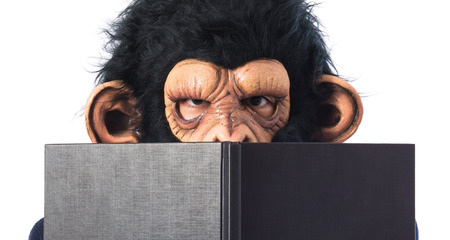 ape man hiding behind a bookの写真素材