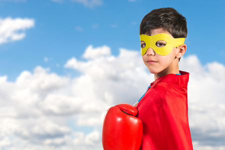 Confident child dressed like superhero with boxing glovesの写真素材