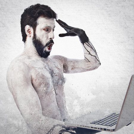 Surprised primitive with laptopの写真素材