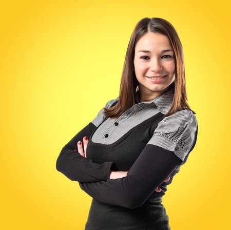 Young woman with hers arms crossed over white backgroundの写真素材