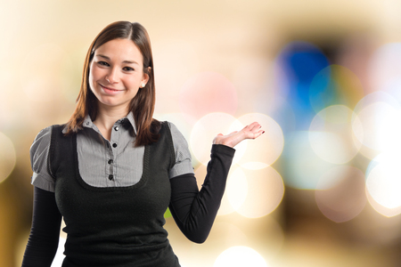 Young pretty woman holding something over white backgroundの写真素材