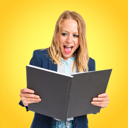 Girl reading a book over white backgroundの写真素材