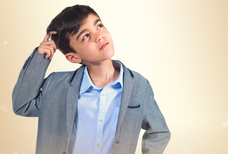 Child thinking over white backgroundの写真素材