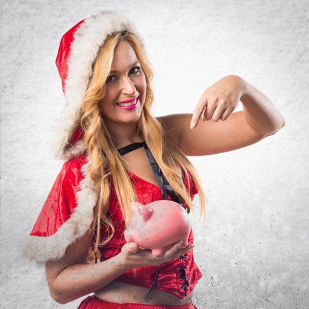 Christmas woman holding a piggybankの写真素材