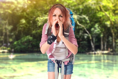 backpacker shouting over isolated white backgroundの写真素材