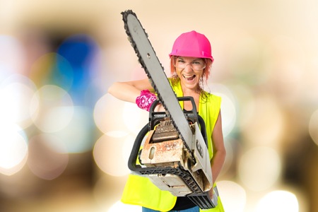 Worker woman with chainsaw over white backgroundの写真素材
