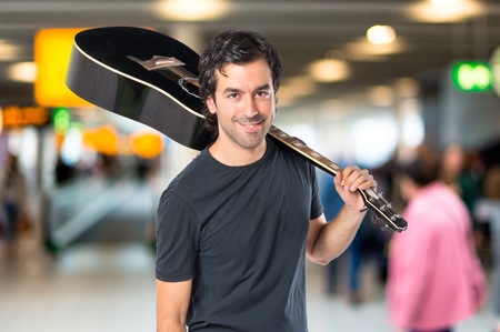 Handsome man with guitar over white background