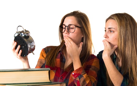 Students holding vintage clockの写真素材