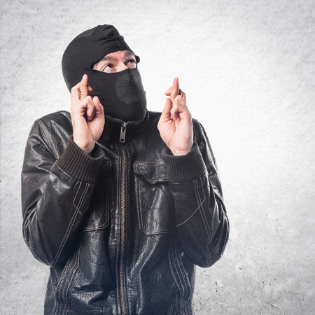 Robber with his fingers crossingの写真素材