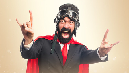 Super hero businessman making horn gestureの写真素材