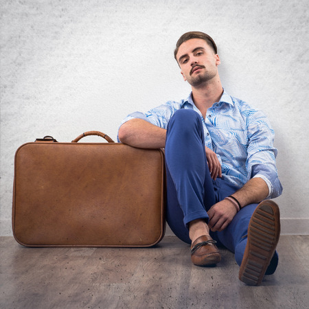 Model man in studio with suitcaseの写真素材