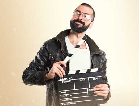 Man wearing a leather jacket holding a clapperboardの写真素材