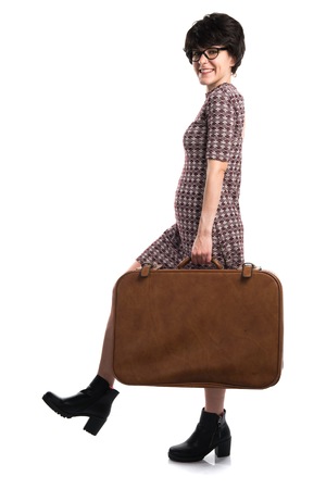 Girl with vintage look holding a suitcaseの写真素材