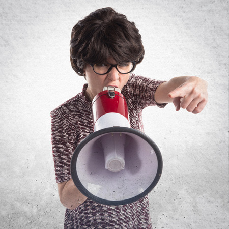 Brunette girl shouting by megaphoneの写真素材