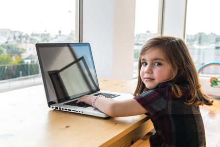 Little kid playing with laptop