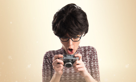 Surprised girl with pop look holding a camera