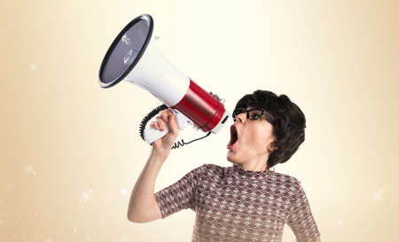 Brunette girl shouting by megaphoneの写真素材