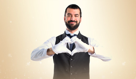 Luxury waiter making a heart with his hands